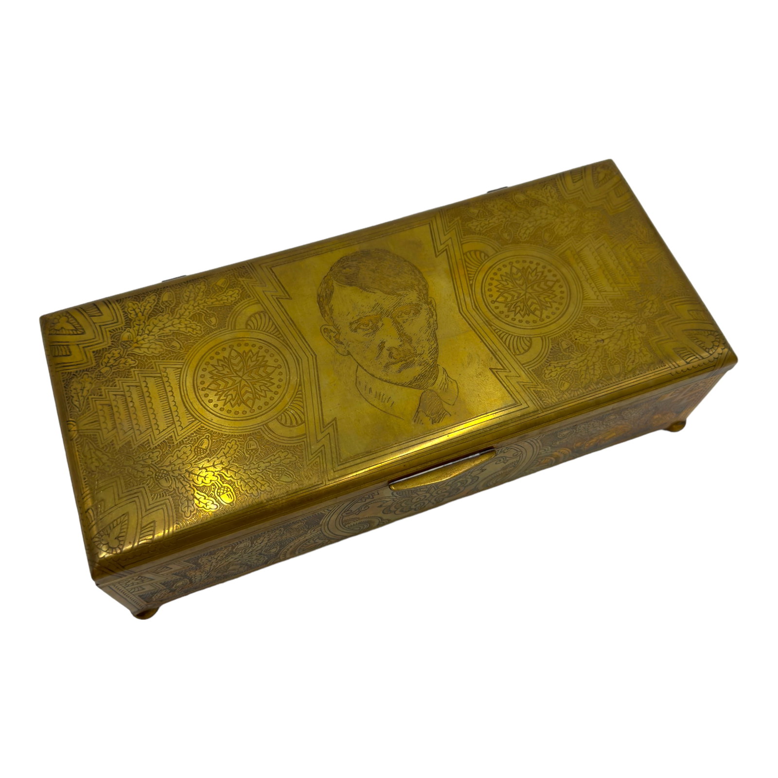 Adolf Hilter Brass Tobacco Box: Third-Reich brass finish footed tobacco box. Lid has an engraved portrait of Adolf Hitler. The surrounding area and entire surface of the box is profusely etched with geometric patterns and branches o
