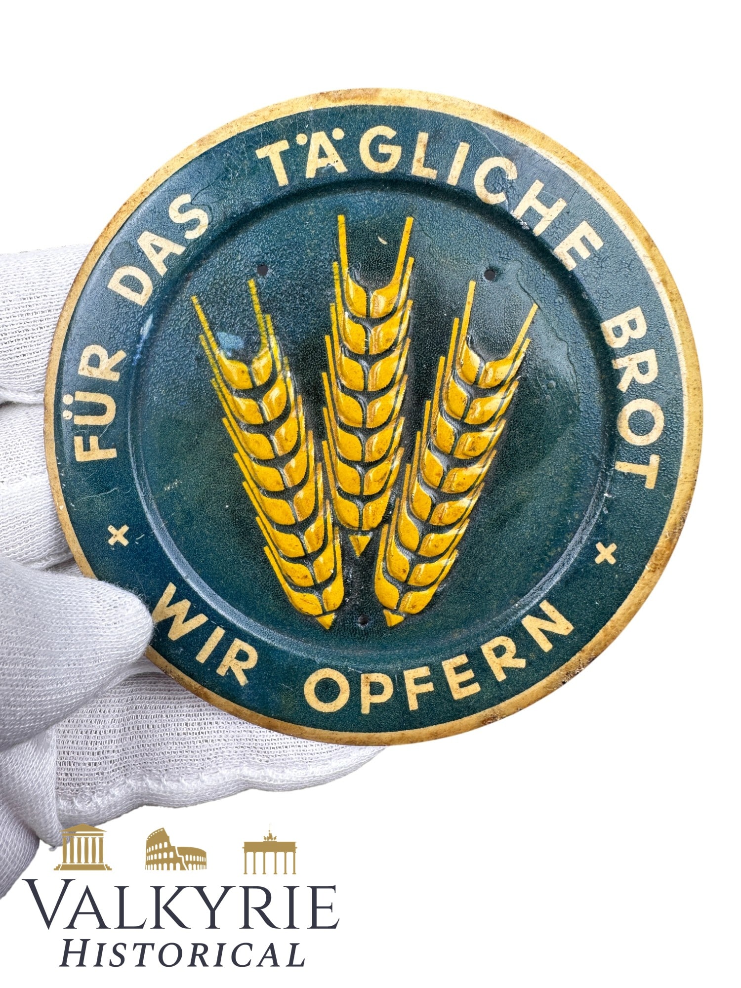 German WHW Commemorative Badge "For the Daily Bread We Make Sacrifices": German WHW Commemorative Badge "For the Daily Bread We Make Sacrifices". Printed metal. With holes to stitch it to the clothes. All items for this auction will be shipping from Europe. Shipping cost $