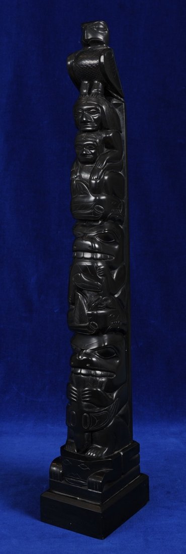 Tom Hans Argillite Totem Carved with Eagle, Gunarah and: Tom Hans Argillite Totem Carved with Eagle, Gunarah and Wife, Wasco with Three Killer Whales and Bear with Raven in Mouth on a Frog Base 20" H. 3" W. Base 4" Deep Fine Condition