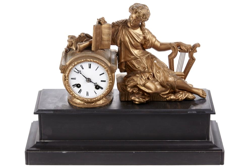 French Gilt Metal & Marble Figural Mantle Clock: French gilt metal and marble figural mantle clock which is modeled with a classical female musician reclining upon a drum clock with a 9cm white enameled dial and and two train movement, mounted upon