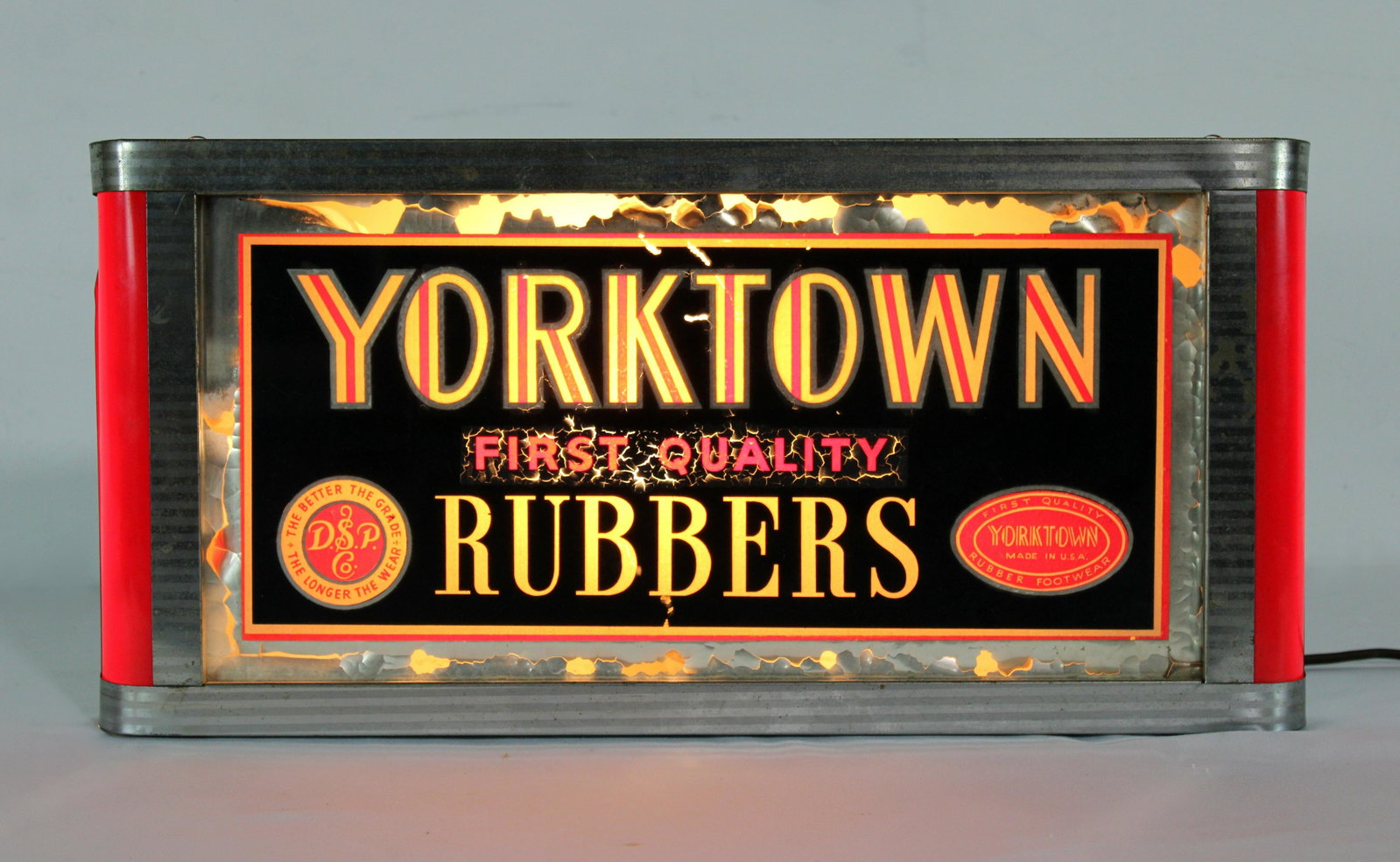 Yorktown Rubbers Reverse on Glass Art Deco Light Up Sign: Yorktown Rubbers Reverse on Glass Art Deco Light Up Sign. Working. Paint flaking. This item requires third party shipping or pickup arrangements to be made. Dimensions:9 x 19 x 5