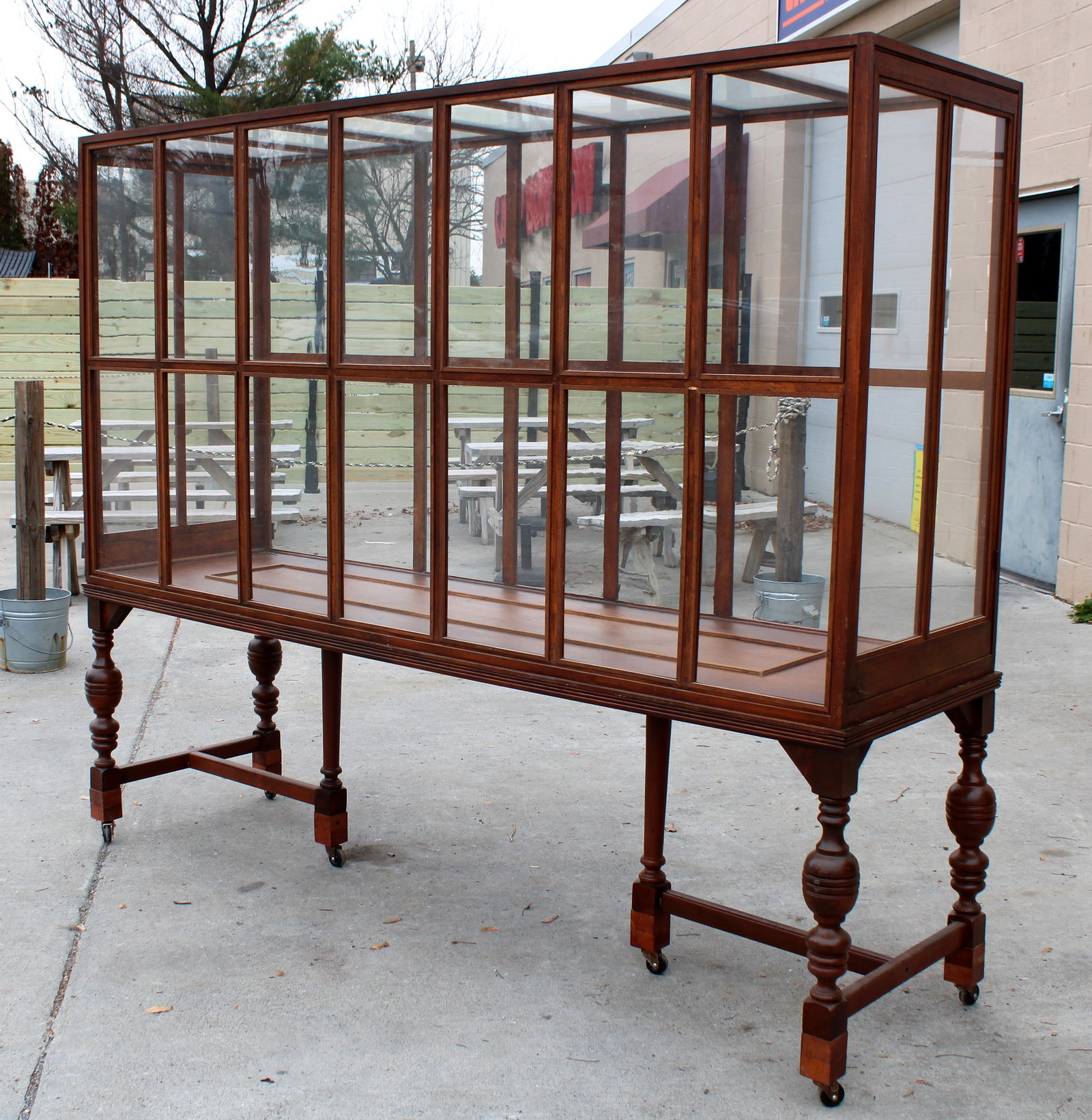 Oversized Glass and Wood Display Case (8 FT): Breaks into two pieces for transport. Appears to be for a ship model. Bottom bar needs re-attached (see photos).This item requires third-party shipping or pickup arrangements to be made. Dimensions: 7