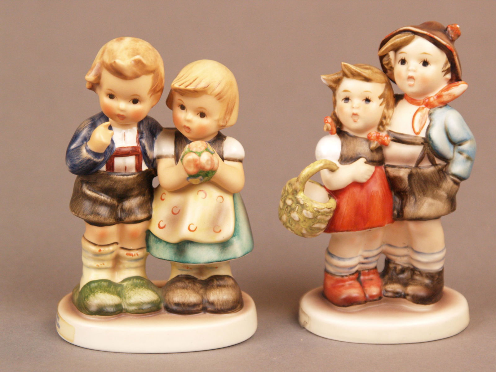 Konvolut Goebel Hummelfiguren - 2 Kinderpaare, blaue: Konvolut Goebel Hummelfiguren - 2 Kinderpaare, blaue Manufakturmarke, polychrom bemalt, 1x "Hänsel und Gretel", Mod.Nr. 94 3/0, Hut, Mädchenfrisur und Stand bestoßen, 1x "Wir gratuliere