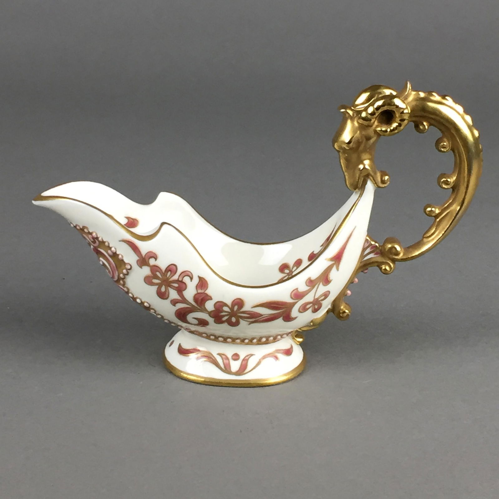 Sauciere - Ungarn, Zsolnay, Pécs, Porzellan, weiß: Sauciere - Ungarn, Zsolnay, Pécs, Porzellan, weiß glasiert, teils reliefierter, floraler Dekor, vergoldeter Widderkopf-Henkel, Boden gemarkt, HxL.ca.11x17,5cm