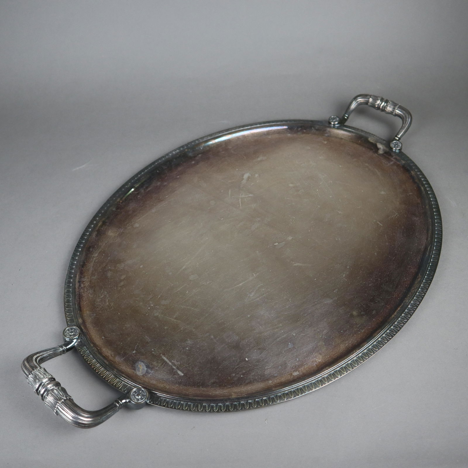 Großes Tablett - Christofle, Frankreich, 20.Jh.,: Großes Tablett - Christofle, Frankreich, 20.Jh., Metall versilbert, ovales Tablett mit seitlichen Tragegriffen, Modell "Malmaison", Reliefrand mit Blattdekor, profilierte Griffe mit reliefierten