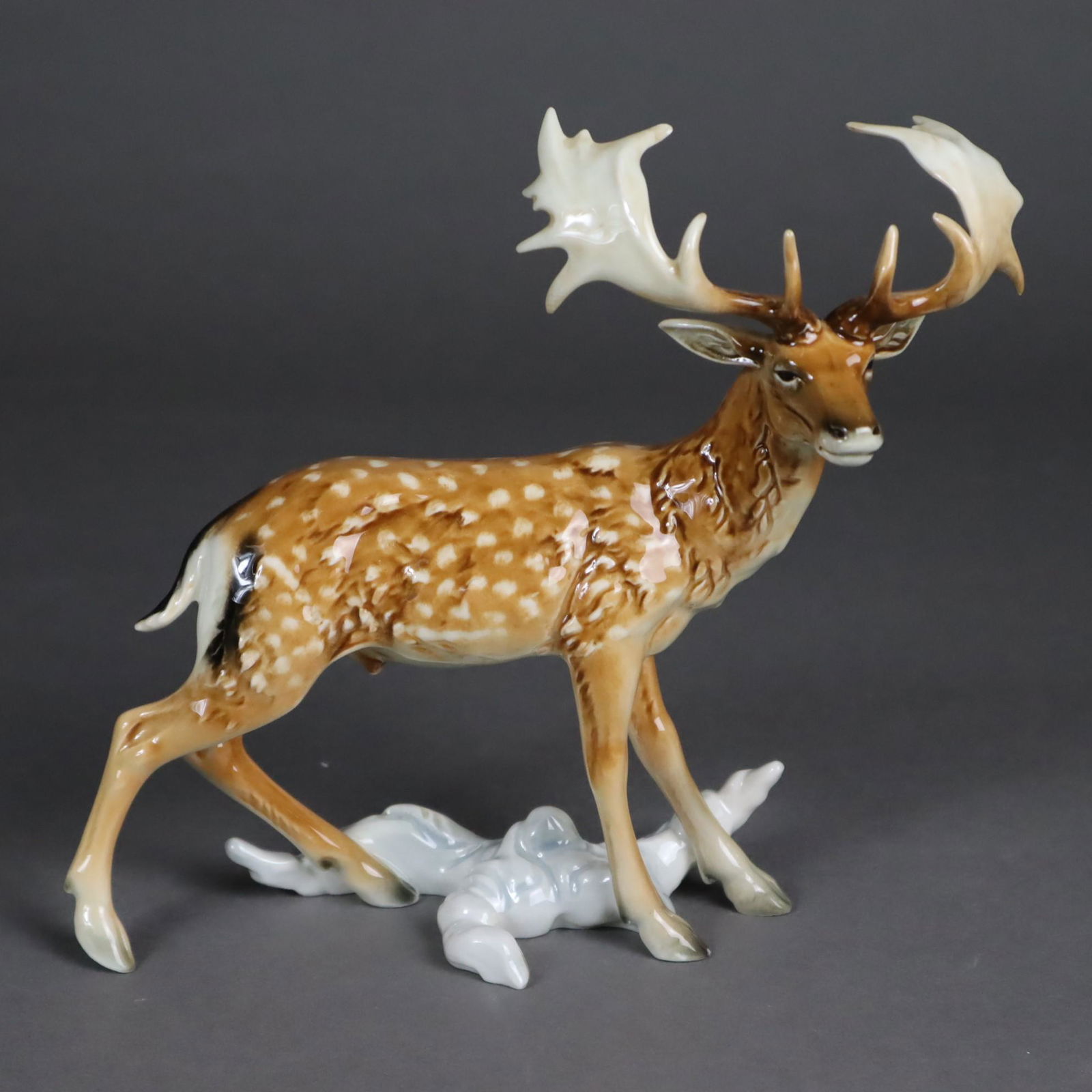 Tierplastik "Damhirsch/Fallow Deer/Daim" - Goebel,: Tierplastik "Damhirsch/Fallow Deer/Daim" - Goebel, Porzellan, polychrom bemalt, Boden mit Manufakturmarke 1979-1990 und Original-Etikett, Modellnr."020", HxL.ca.18x21cm, seht guter Zustand German Cate