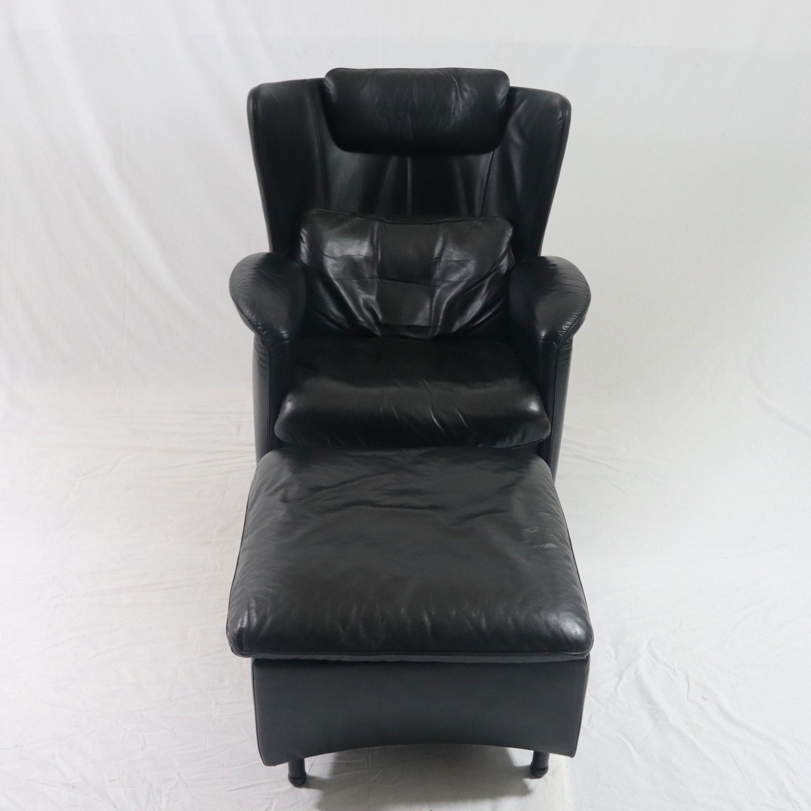 Ledersessel mit Fußhocker- De Sede, Schweiz, Modell DS-609, Nr. 1106-10898, schwarzer: Ledersessel mit Fußhocker- De Sede, Schweiz, Modell DS-609, Nr. 1106-10898, schwarzer gepolsterter Lederbezug, Nackenkissen, H x B x T: ca. 99 x 82 x85 cm, Hocker ca. 40 x 59 x 59cm, beide mit He