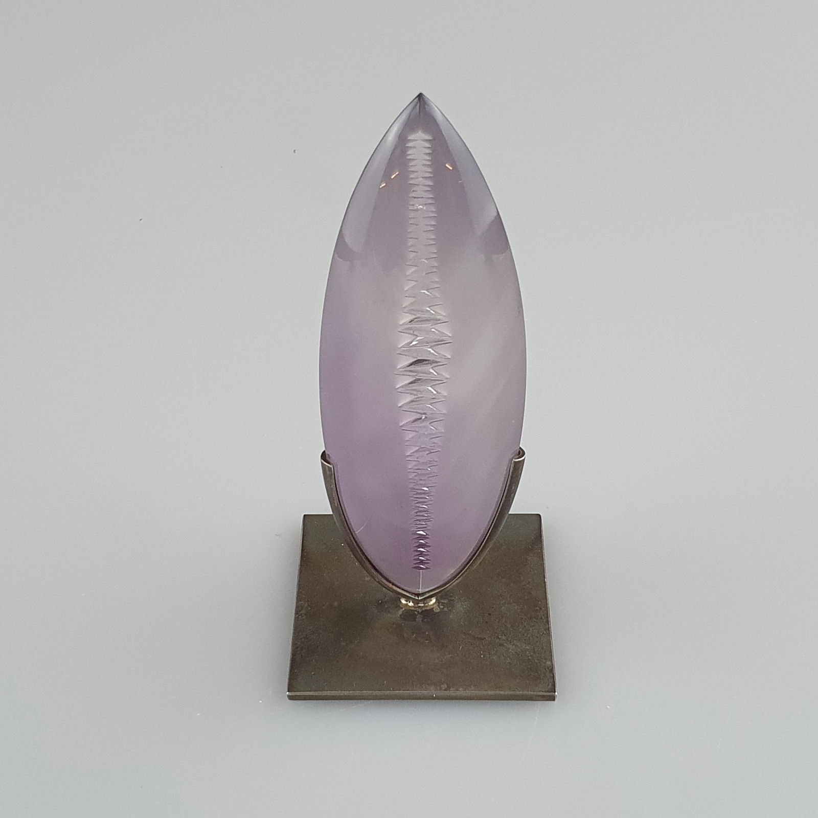 Kleine Amethyst-Skulptur "Imagination" - ATELIER MUNSTEINER, Stipshausen (nahe Idar-Oberstein),: Kleine Amethyst-Skulptur "Imagination" - ATELIER MUNSTEINER, Stipshausen (nahe Idar-Oberstein), navetteförmiger Amethystcabochon, fein poliert, rückseitig gefrostet und graviert, zonare Farb