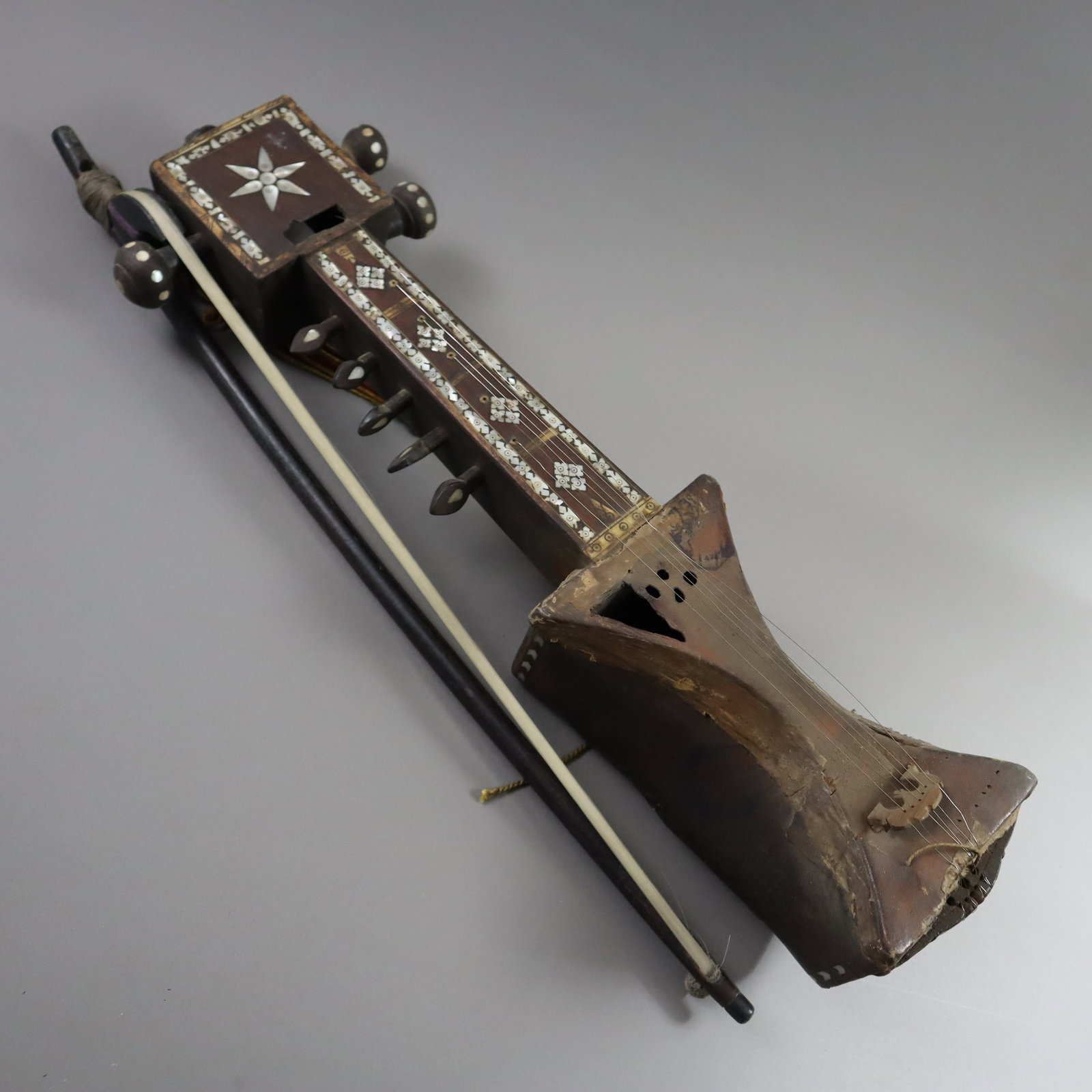 Saiteninstrument Sarangi - Indien/Pakistan/Afghanistan, Holzkorpus mit Perlmutteinlagen, taillierter: Saiteninstrument Sarangi - Indien/Pakistan/Afghanistan, Holzkorpus mit Perlmutteinlagen, taillierter Resonanz-Körper mit Tierhaut bespannt, mit Bogen, älter, zeitbedingte Gebrauchsspuren, Be
