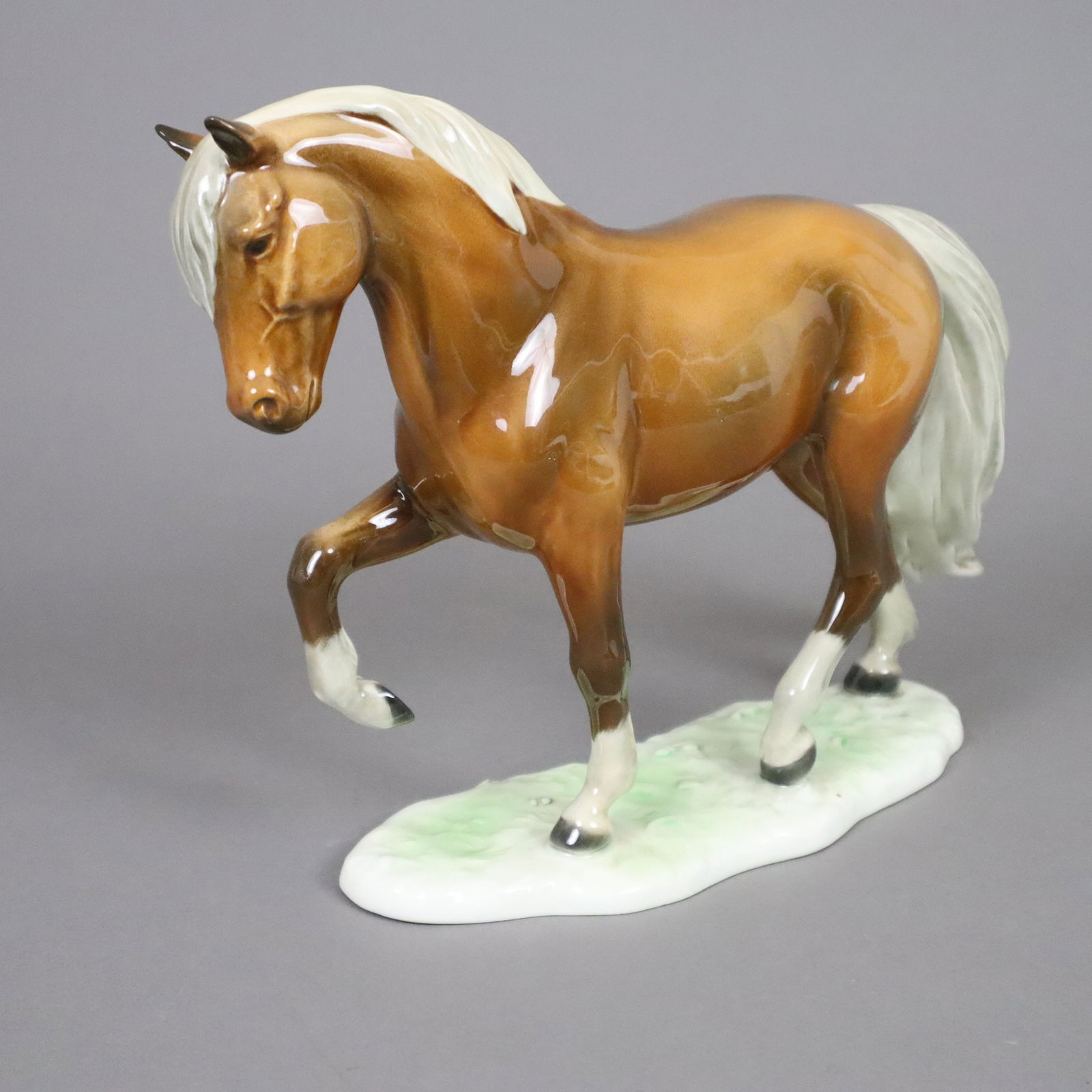 Trabendes Pferd - Goebel, Entwurf von G. Bochmann (1977),: Trabendes Pferd - Goebel, Entwurf von G. Bochmann (1977), Keramik, polychrom bemalt, auf Grasplinthe signiert "Bochmann", Boden mit Manufakturmarke 1979-1990, Jahr und Modellnummer 32 307 18, HxL: ca.