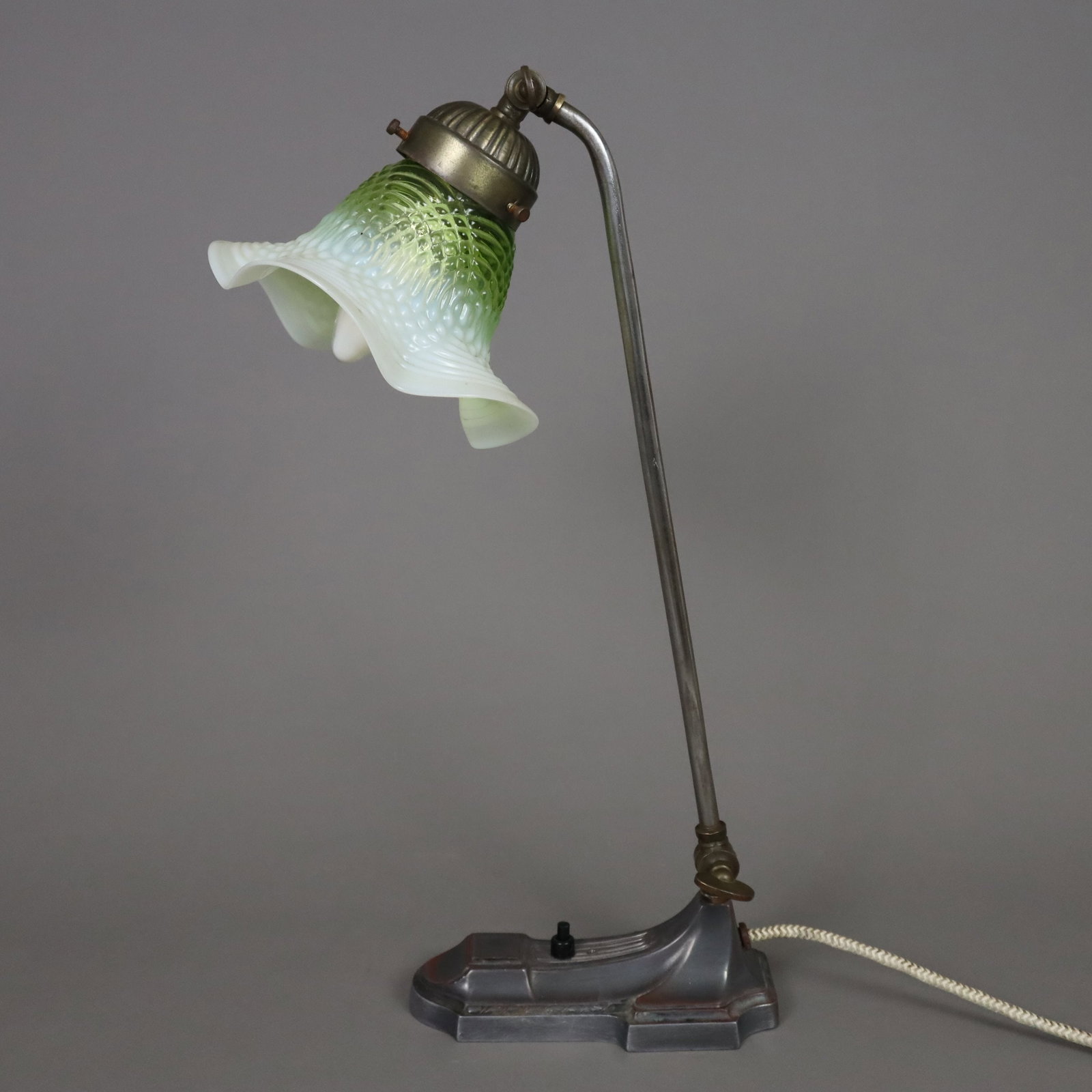 Tischlampe - Art Déco, um 1930, Metallguss zinnfarben patini: Tischlampe - Art Déco, um 1930, Metallguss zinnfarben patiniert, stiltypisch reliefierter Fuß mit integriertem Druckschalter, gebogener Rohrarm mit Gelenk, tulpenförmiger Schirm aus wei