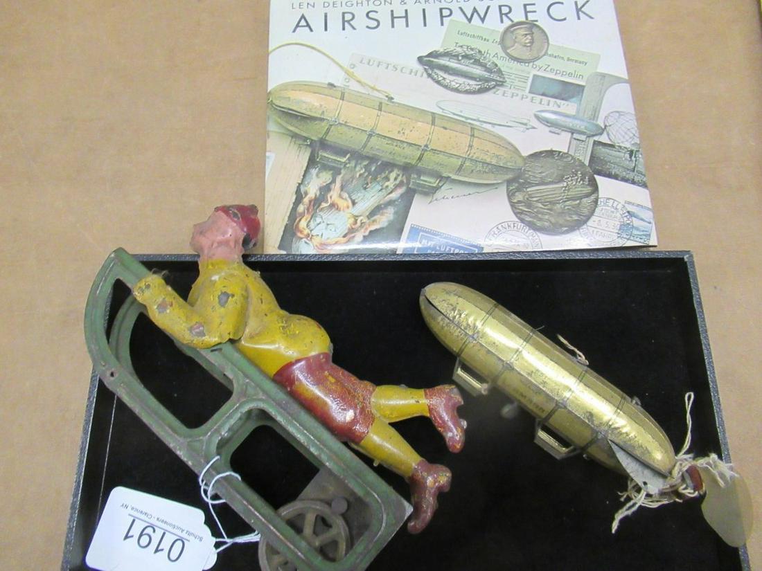 TOY ZEPPLIN, AIRSHIP BOOK, AND METAL TOY: TOY ZEPPLIN, AIRSHIP BOOK, AND METAL TOY BOY ON SLED WITH WHEELS