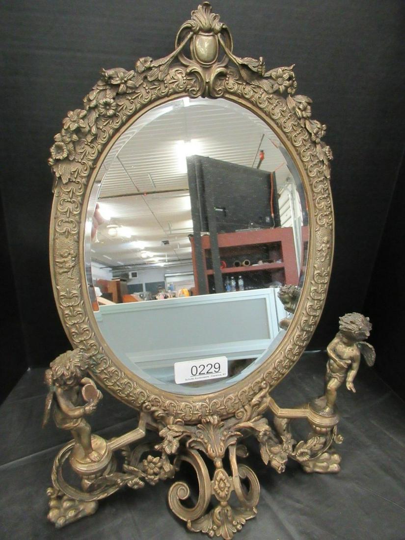 Metal Framed Mirror w/ Cupid Figures: Metal Framed Mirror w/ Cupid Figures, Approx. 22"h x 15" wide at base x 9" front to back at base
