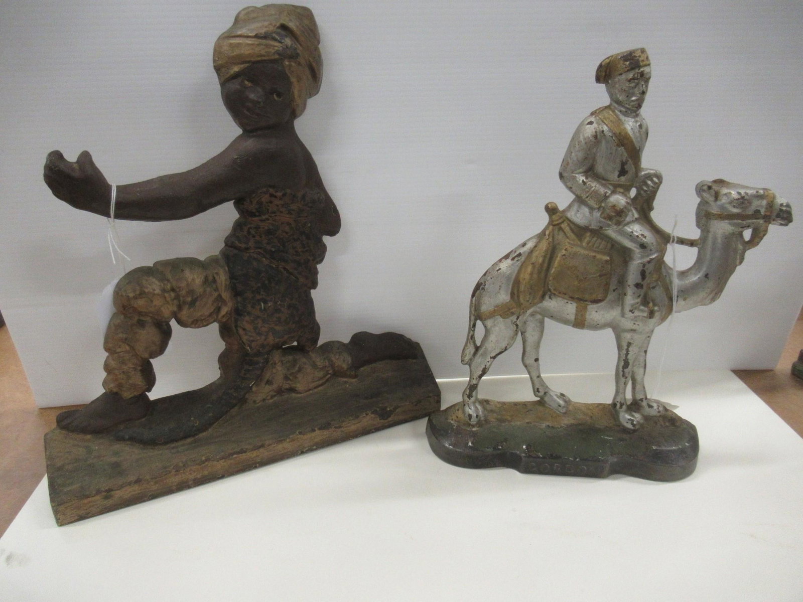 2 Cast Iron Door Stops: 2 Cast Iron Door Stops, 1 of Man on Camelback & Young Boy -