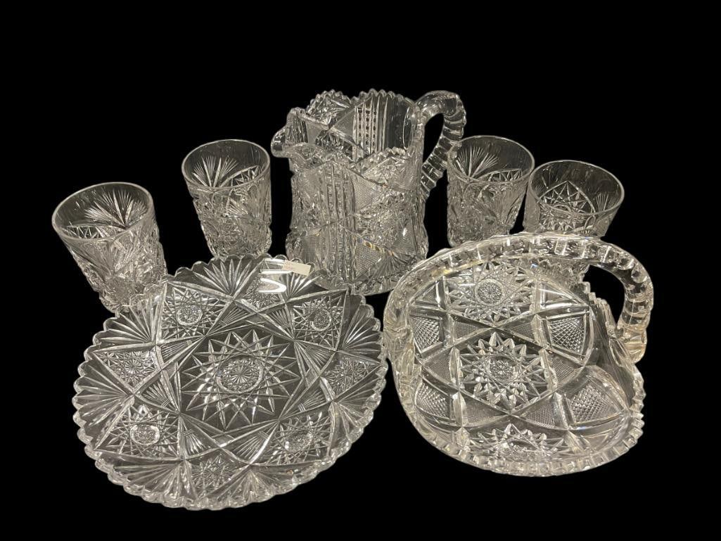 Assorted Cut Glass Serveware: Cut glass pitcher and 4 glasses, pitcher is approx 6"x 7.5" with handle, glasses are 4"h, Includes dish with handle like basket 8"x6"