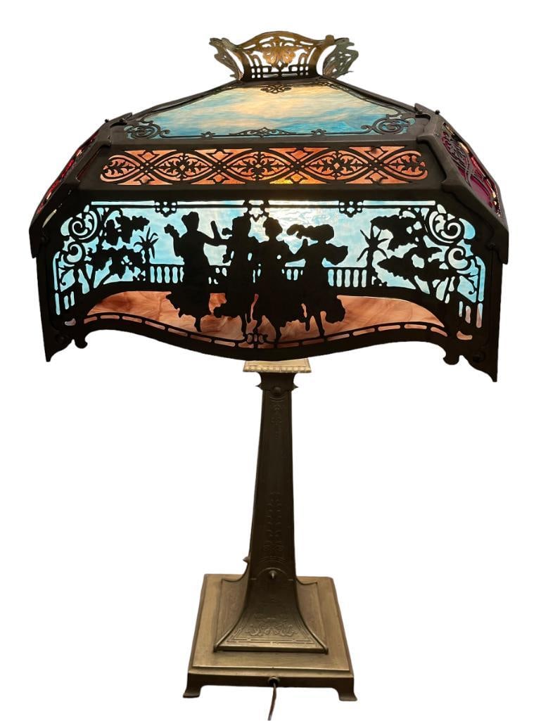 Slag glass lamp with metal overlay of women dancing: Slag glass lamp with metal overlay of women dancing. Approx. 27x15x15 inches.