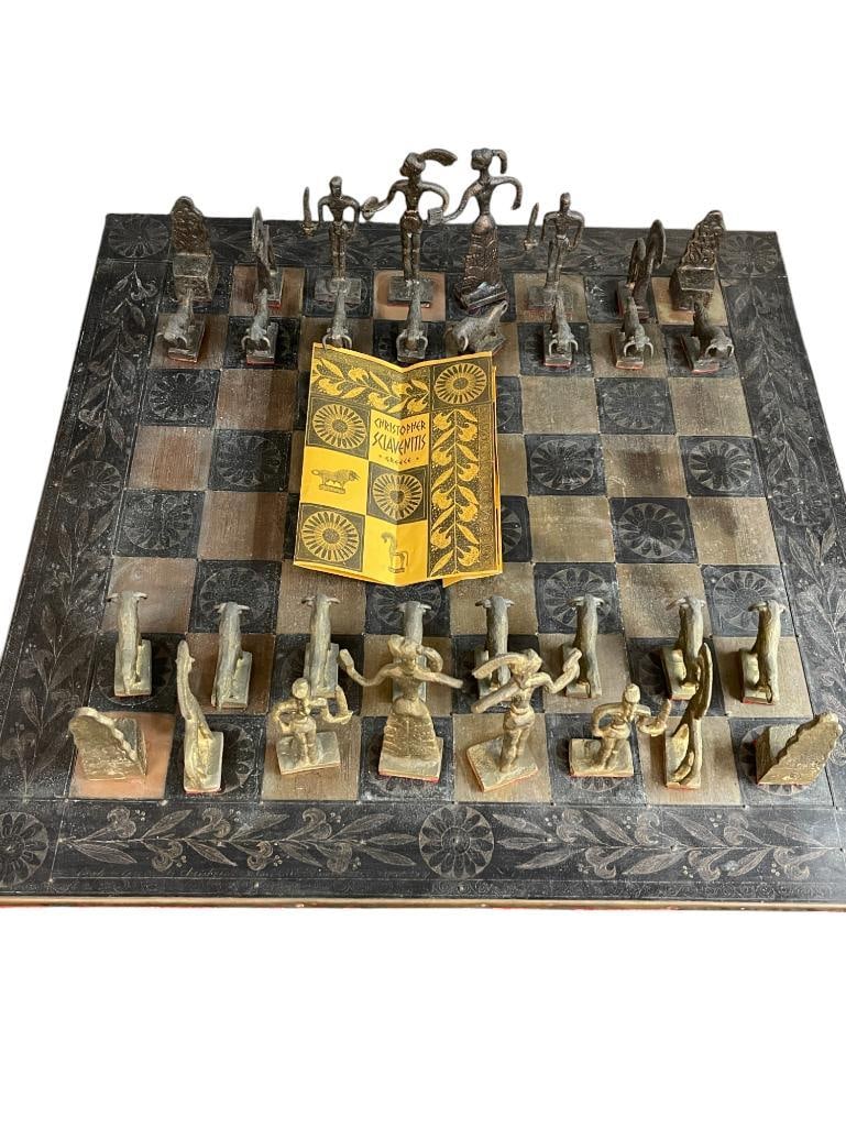 Christoforus Sklavenitis Minoan Chess Set and Board 1971: Christoforus Sklavenitis Minoan Chess Set and Board 1971. Chess board is wood covered in bronze sheets. Hand engraved motifs. Board is signed and numbered, dated 1971. Approx. 23.75x23.75 inches.