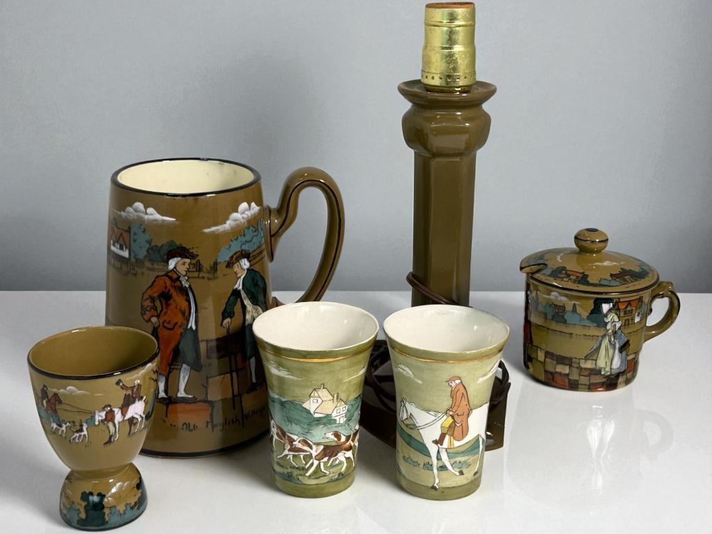 Buffalo Pottery Deldare Ware Tankard Cups and more: Buffalo Pottery Deldare Ware Tankard, Chocolate Cups, Candlestick converted to lamp and more. 6 pieces. Tankard approx. 7 x 5 x 5 inches.
