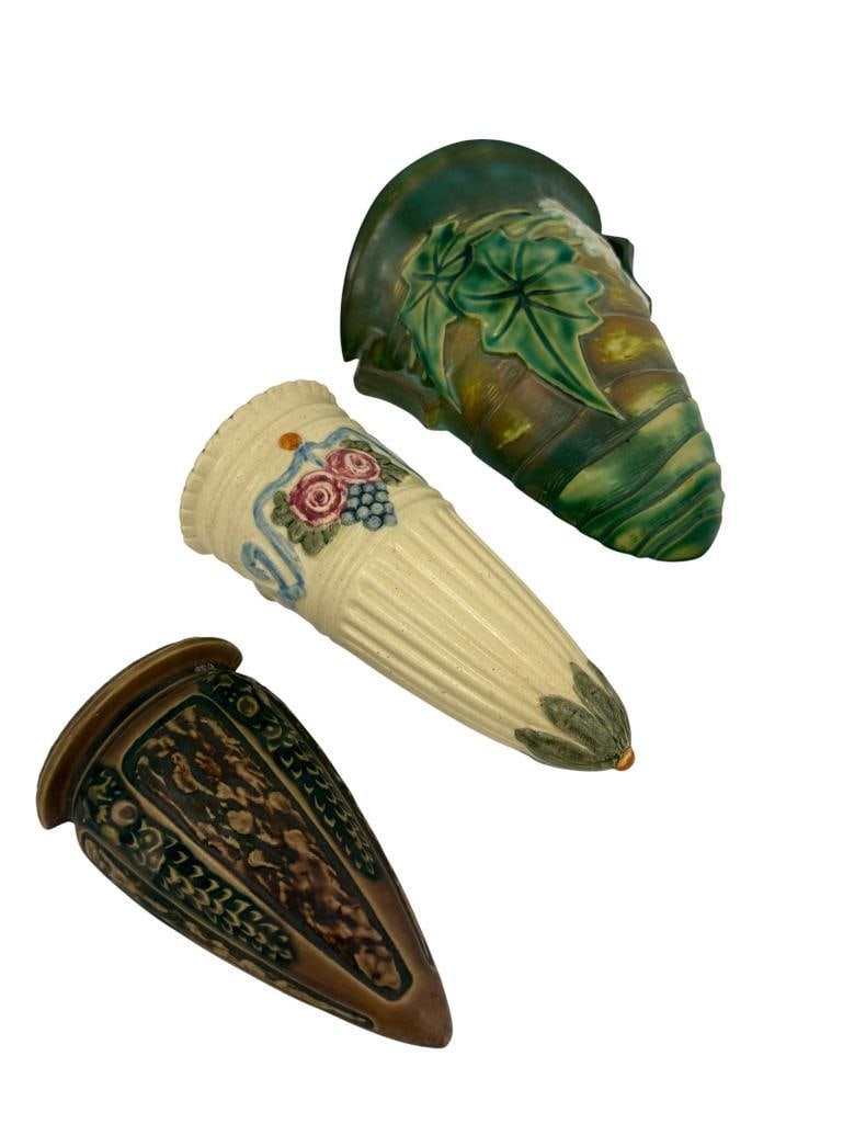 Roseville and Weller wall pockets: Roseville and Weller wall pockets. 3 pieces. Including Roseville Luffa Green and Florentine. Weller Roma. Luffa approx. 6 x 8.5 inches.