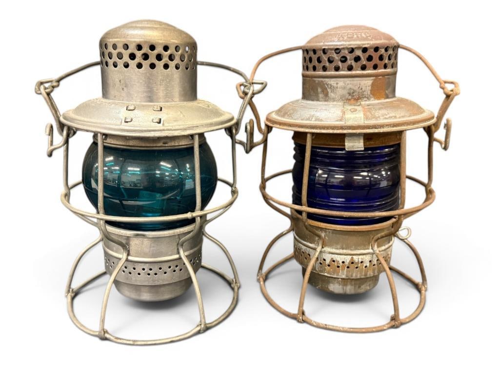 2 Railroad Lanterns: 2 Railroad Lanterns with blue lenses. Adlake and Hiram Piper marked CPR. Approx. 9 x 7 x 7 inches.