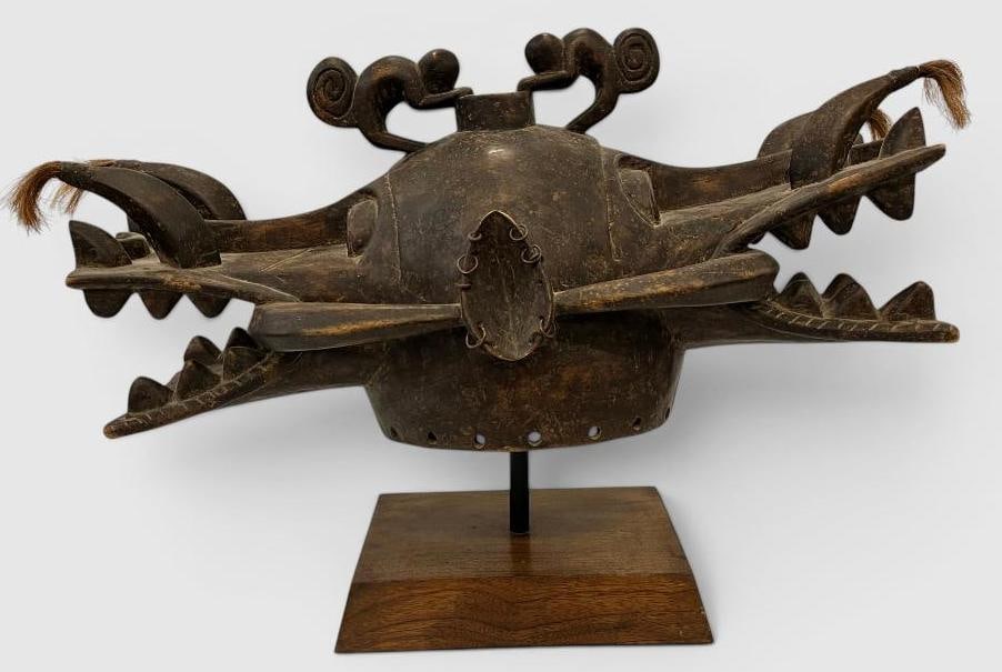 African carved helmet mask: African carved helmet mask. Approx. 28 x 18 x 10 inches on stand. Provenance: These pieces come from the Herbert F. Johnson Museum of Art at Cornell University NY.