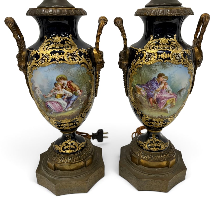 Pair of Sevres Urns / Lamps: Pair of Sevres Urns mounted as Lamps with gold gilt and courting scenes. Signed Lancry. Approx. 28 inches tall.
