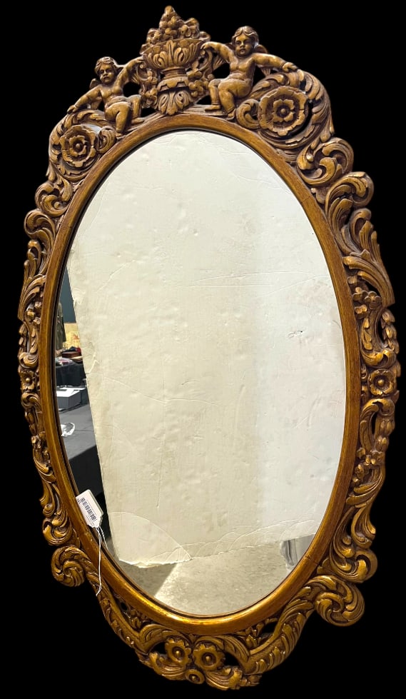 Carved Oval Mirror with Cherubs: Carved Oval Mirror with Cherubs. Approx. 48 x 29 inches.