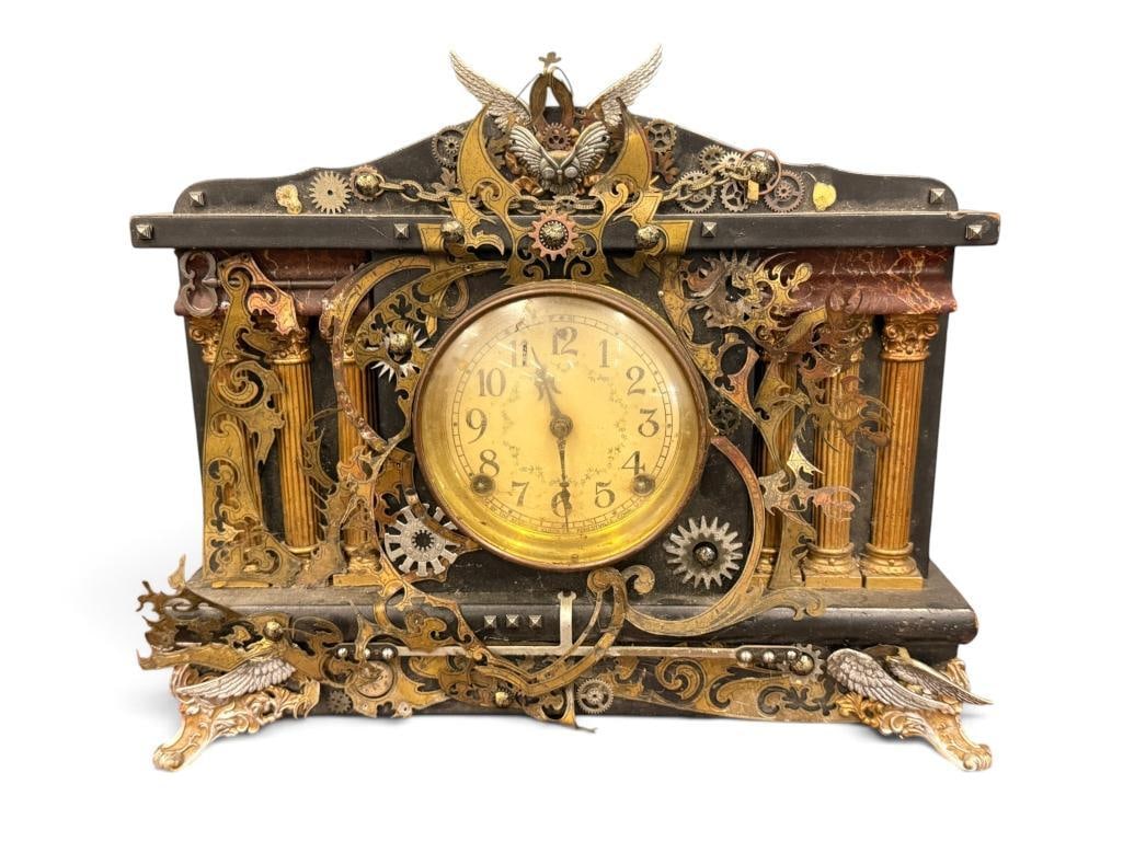 Ornate mantel clock with column accents: Ornate mantel clock with column accents and wing accents. Approx. 14 x 16 x 7 inches.