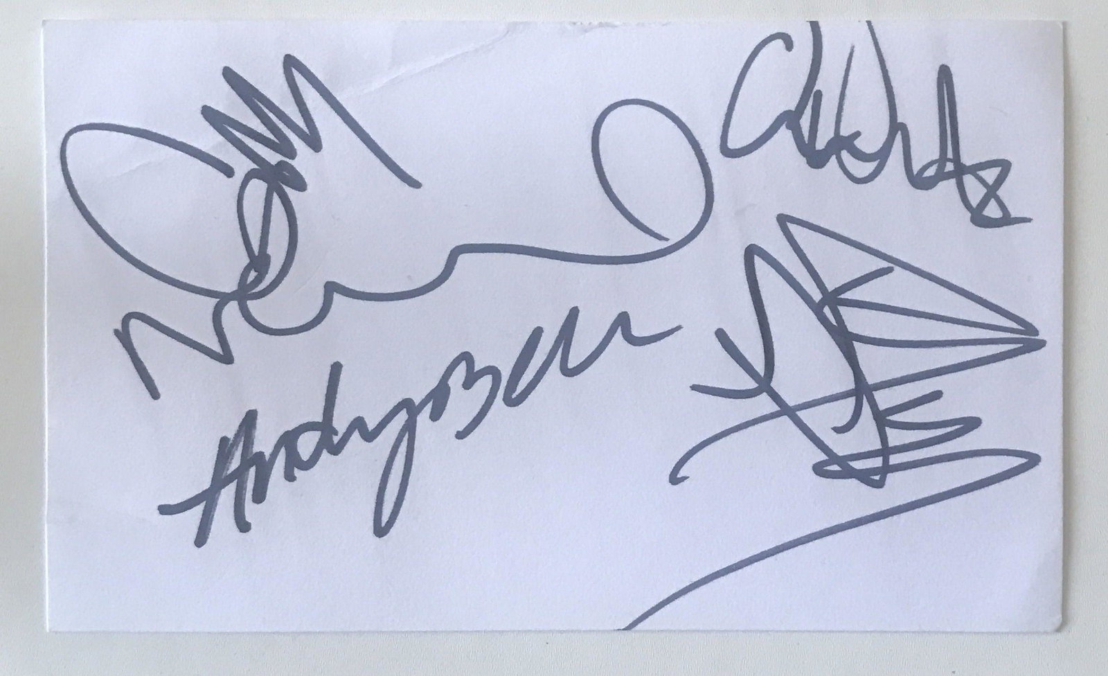 Oasis Fully Signed Vintage Framing Card Certified: A small framing card, autographed by Noel, Liam, Gem, Andy and Alan White in 2002.