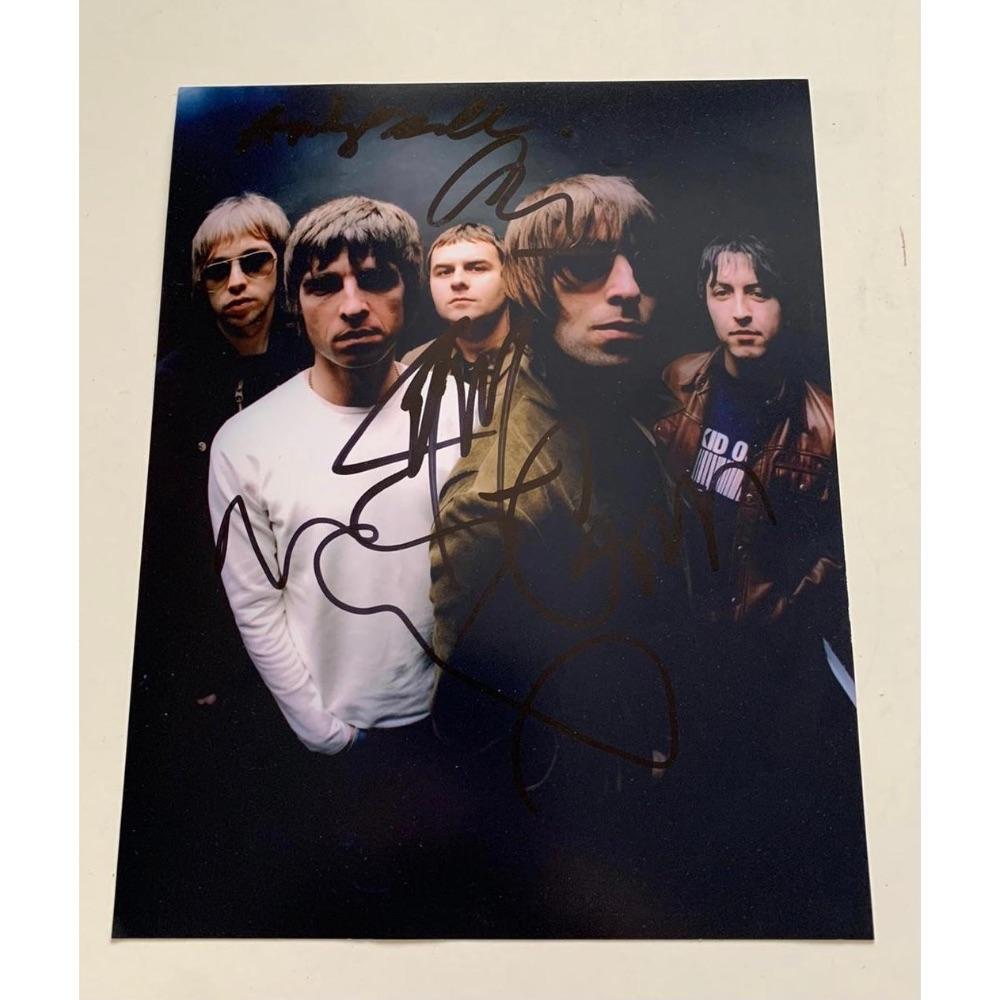 Oasis Fully Signed Photograph Certified: This lot is a photograph autographed by Noel Gallagher, Liam Gallagher, Gem Archer and Andy Bell of Oasis. Item comes with Certificate of Authenticity, guaranteeing it for a lifetime.