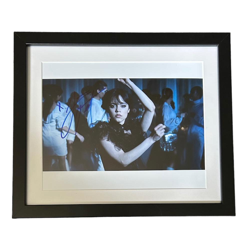 Jenna Ortega Signed Photograph: This lot is a framed 10x8" print autographed by Jenna Ortega. The photo is housed within a mounted black wooden frame, an ideal display item for collectors. Item comes with Certificate of Authenticity