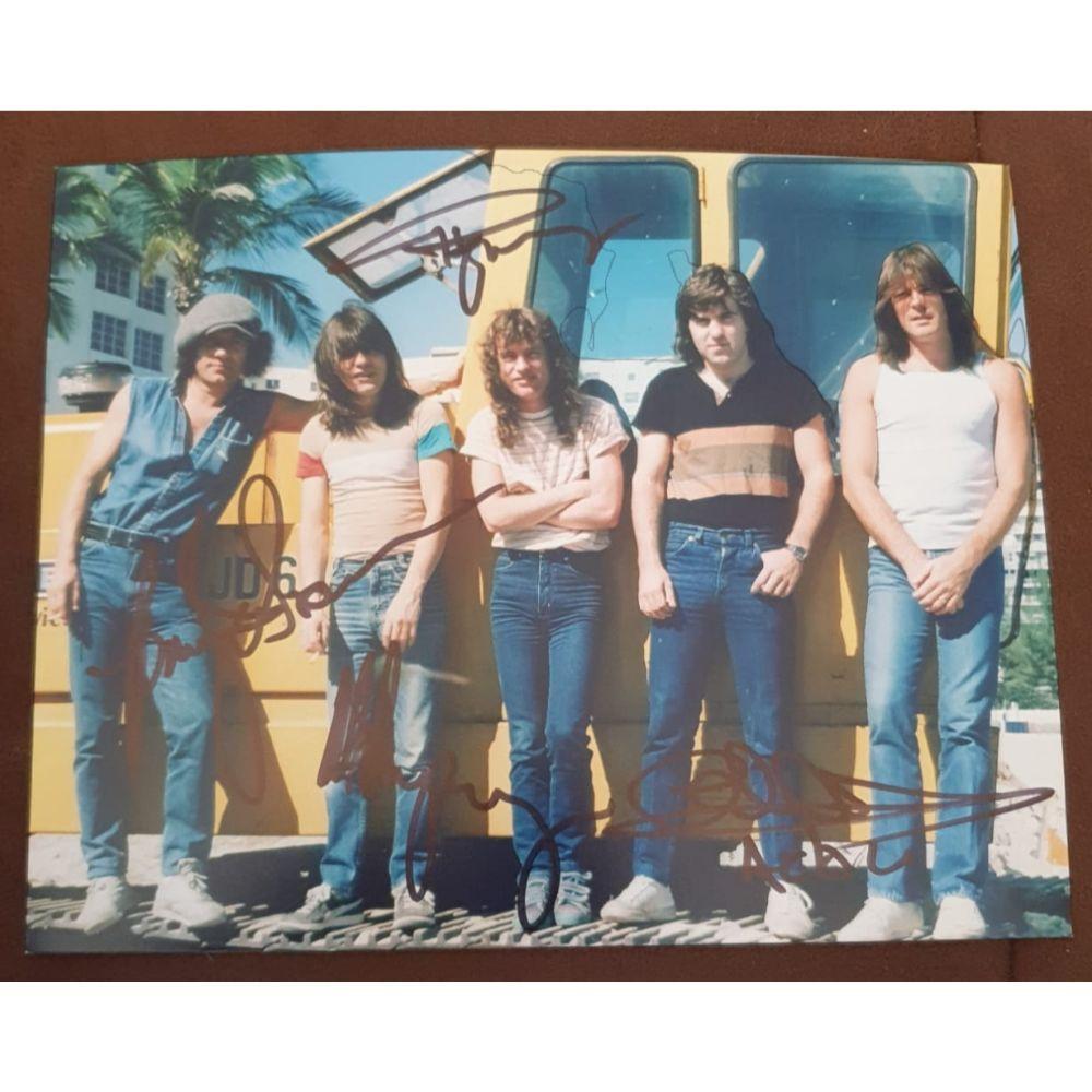 AC/DC Signed Photograph Certified: This lot is a photograph, autographed by Angus Young, Malcolm Young, Brian Johnson and Cliff Williams of AC/DC.