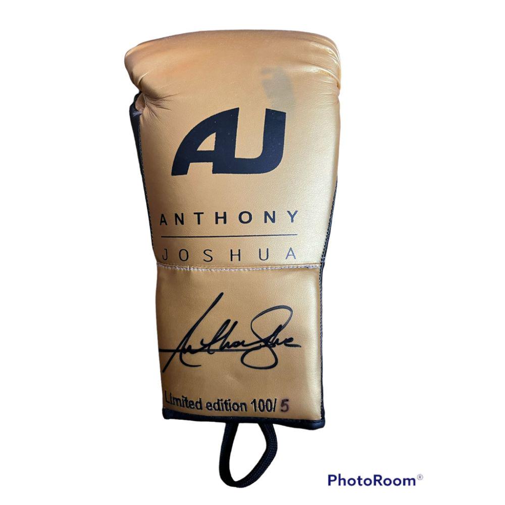 Anthony Joshua Signed Official Gold Boxing Glove: This lot is an official gold Boxing glove, No. 5 of 100 autographed by Anthony Joshua. There is slight discolouration to the glove as can be seen in the photo. Anthony Oluwafemi Olaseni Joshua OBE (bo