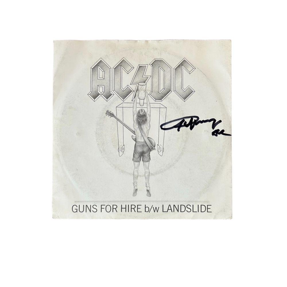 Angus Yound AC/DC Signed 'Guns For Hire' Vinyl 45: This lot is a vinyl 45 'Guns For Hire' autographed on the front cover in black sharpie pen by Angus Young of AC/DC. AC/DC are an Australian rock band, they have sold more than 200 million records worl