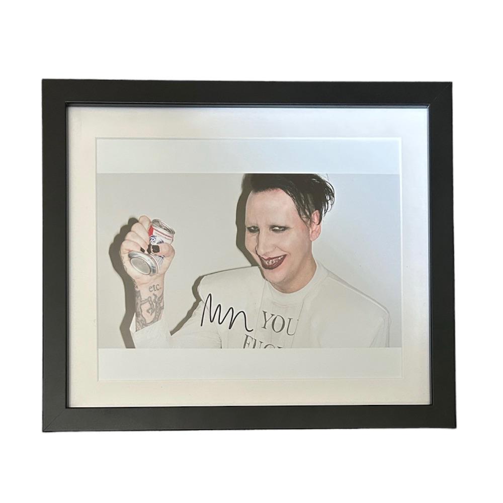 Marilyn Manson Signed Photograph: This lot is a framed 10x8" print autographed by Marilyn Manson. The photo is housed within a mounted black wooden frame, an ideal display item for collectors. Item comes with Certificate of Authentici