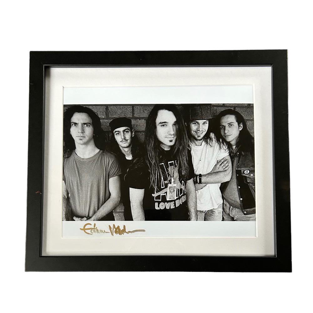 Eddie Vedder Signed Pearl Jam Framed Photograph: This lot is a framed 10x8" print autographed by Eddie Vedder of Pearl Jam. The photo is housed within a mounted black wooden frame, an ideal display item for collectors. Pearl Jam is an American rock 
