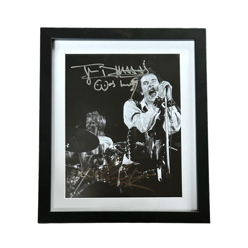 Johnny Rotten Sex Pistols Signed Framed Photograph: This lot is a framed 10x8" print autographed by Johnny Rotten of The Sex Pistols. The photo is housed within a mounted black wooden frame, an ideal display item for collectors. The Sex Pistols were an