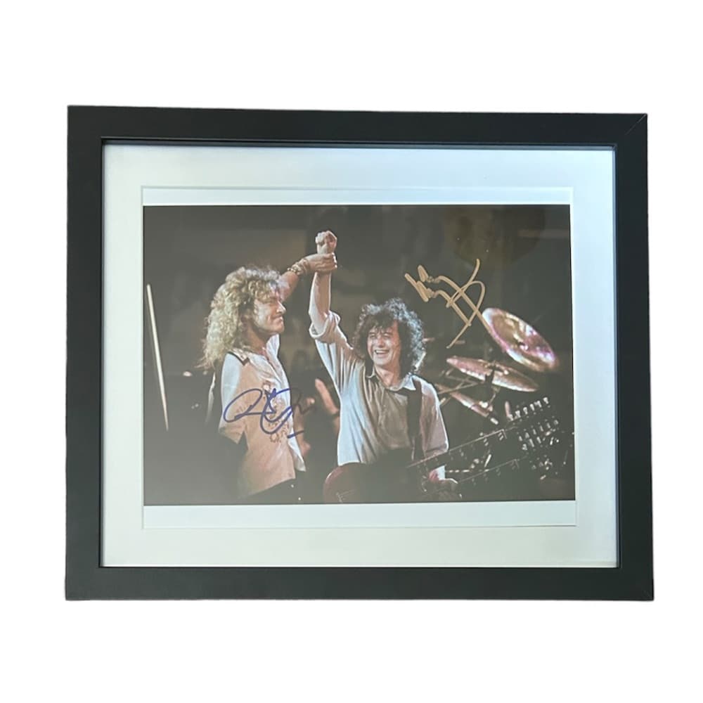 Robert Plant and Jimmy Page Led Zeppelin Signed Photograph: This lot is a framed 10x8" print autographed by Robert Plant and Jimmy Page of Led Zeppelin. The photo is housed within a mounted black wooden frame, an ideal display item for collectors. Item comes w