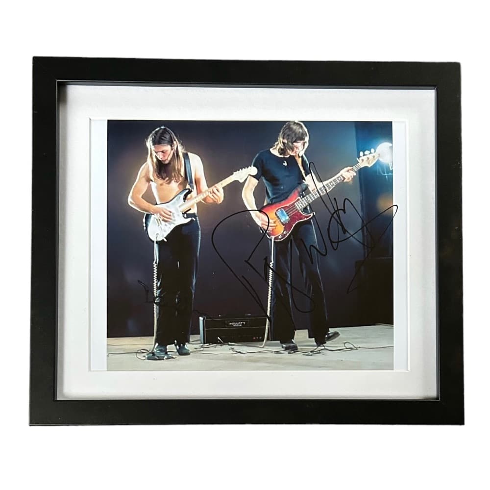 Pink Floyd Signed Framed Photograph: This lot is a framed 10x8" print autographed by Roger Waters and David Gilmour of Pink Floyd. The photo is housed within a mounted black wooden frame, an ideal display item for collectors. Pink Floyd 