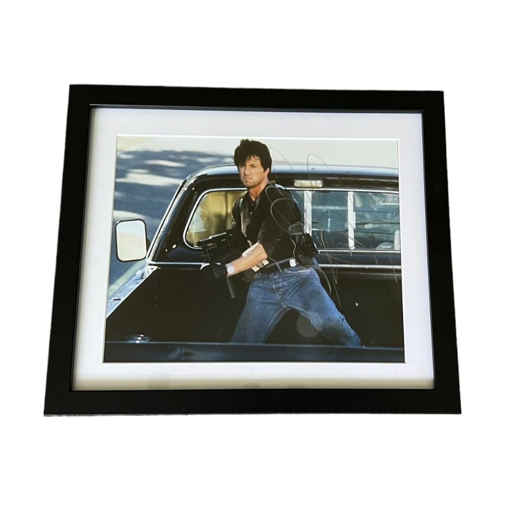 Sylvester Stallone Signed Framed Cobra Photograph: This lot is a framed 10 x 8" Cobra photograph autographed by Sylvester Stallone. Sylvester Gardenzio Stallone ( born July 6, 1946) is an American actor and filmmaker. After his beginnings as a struggl