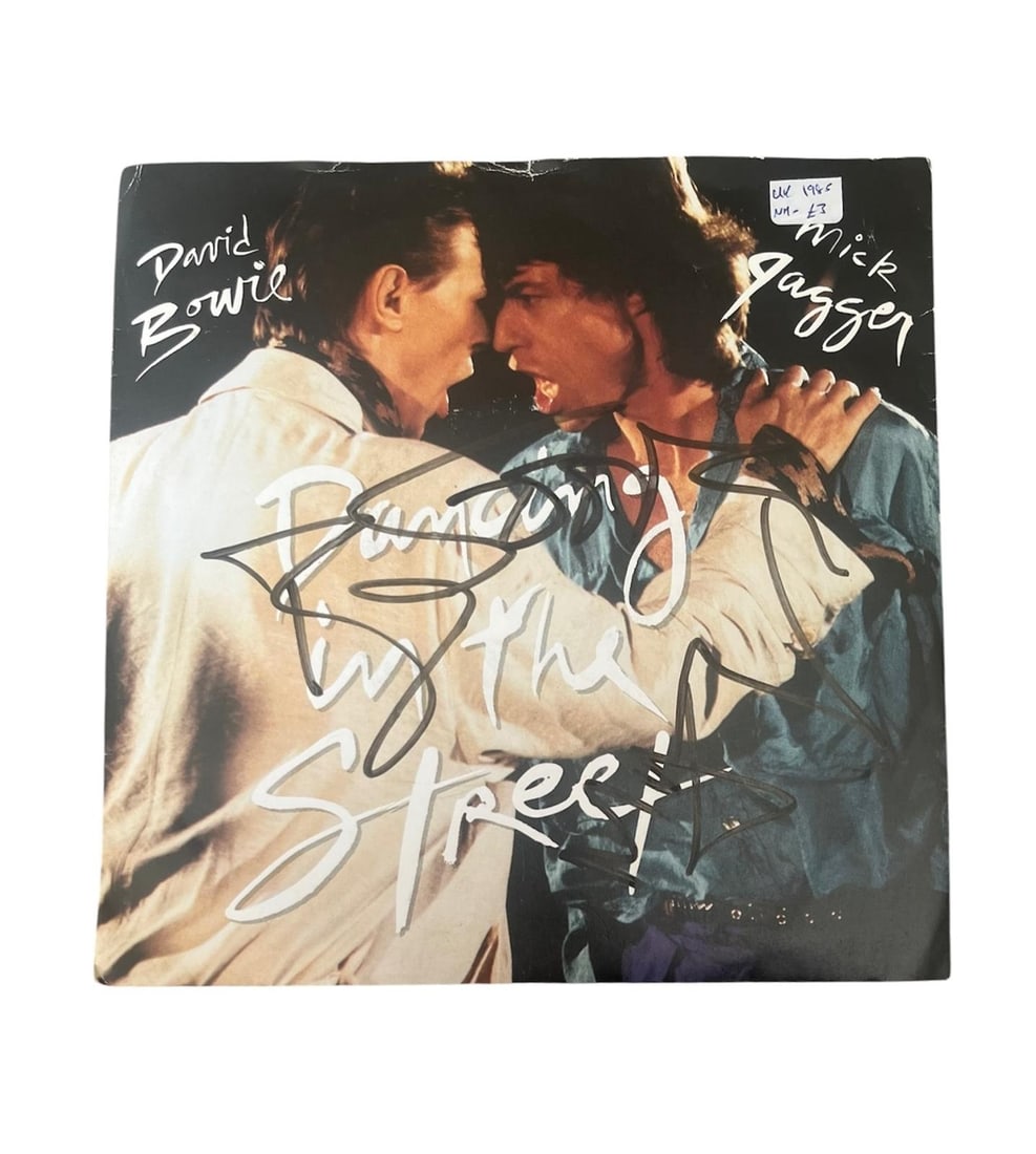 David Bowie And Mick Jagger Signed Vinyl 45: This lot is a vinyl 45 (Dancing In The Street), autographed on the front of the vinyl cover by Mick Jagger and David Bowie. Item comes with third-party authentication and affixed tamper-proof holograp