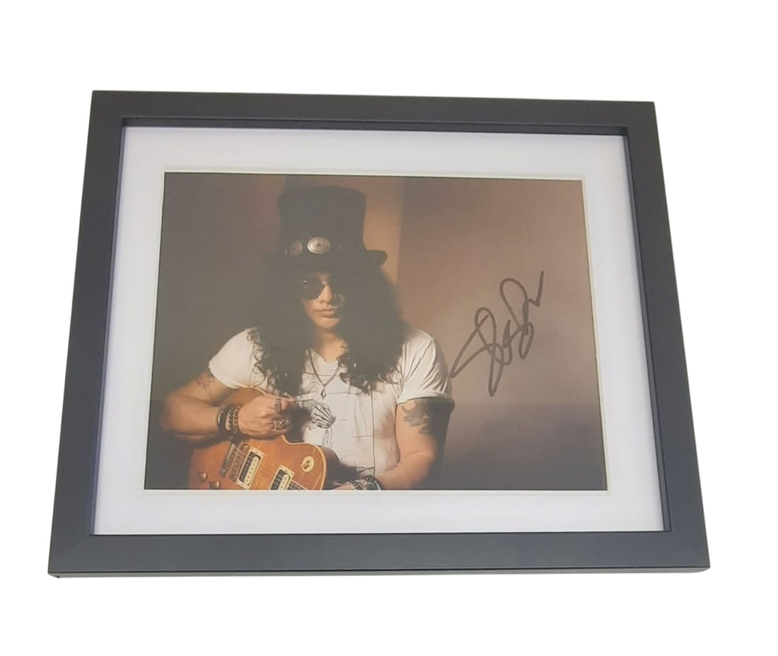 Slash Guns N Roses Signed Framed Photograph: This lot is a framed 10x8" photograph, autographed by Slash of Guns N' Roses. The photo is housed within a mounted black wooden frame, an ideal display item for collectors. Item comes with third-party