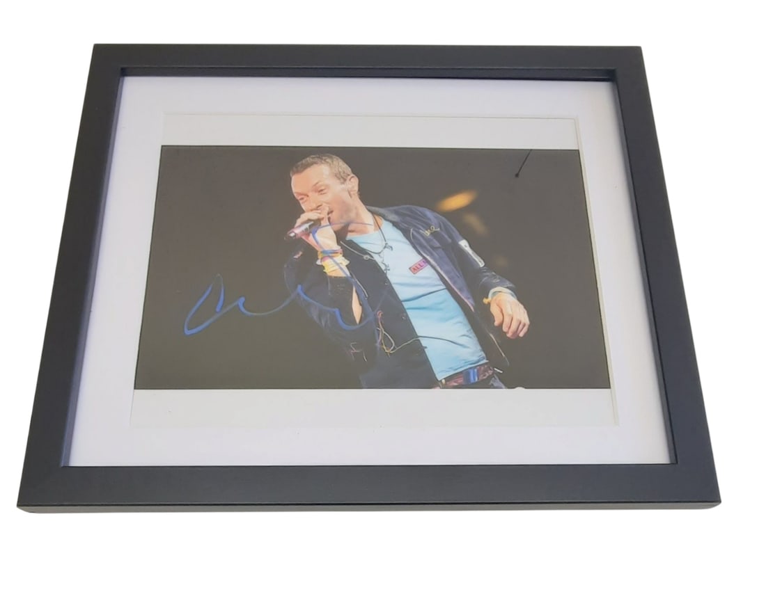 Chris Martin Coldplay Framed Signed Photograph: This lot is a framed 10x8" photograph, autographed by Chris Martin of Coldplay. The photo is housed within a mounted black wooden frame, an ideal display item for collectors. Item comes with third-par