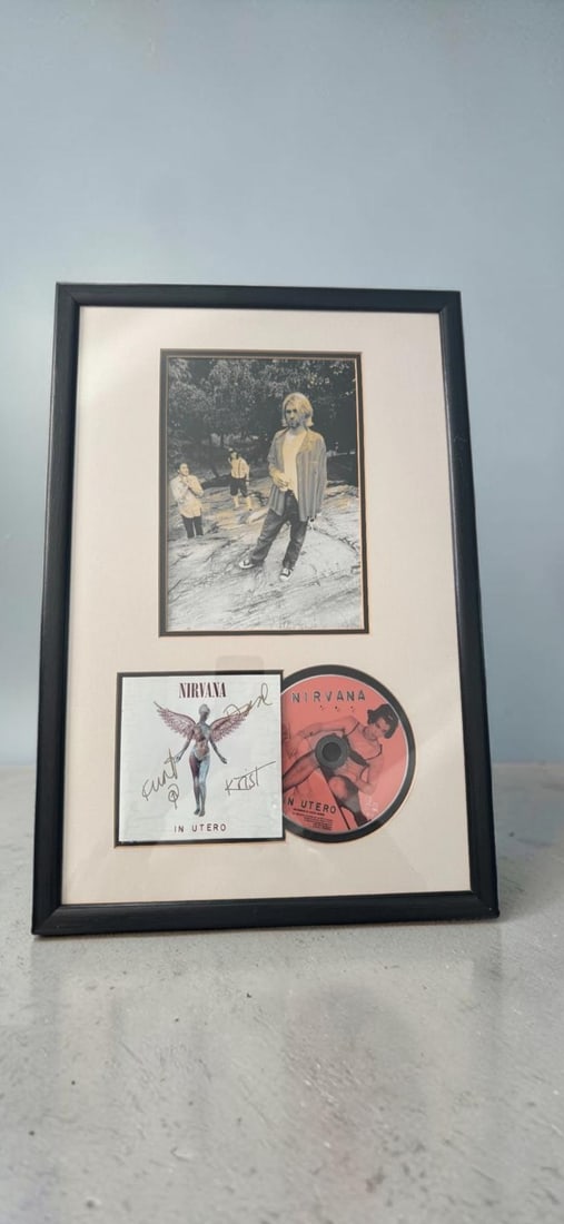 Nirvana Fully Signed In Utero Framed Display: This lot is a Nirvana framed display consisting of a 10x8" mounted photograph, featuring the band. In utero European signed CD, signed on the inlay by Kurt Cobain, Krist Novoselic and Dave Grohl of Ni