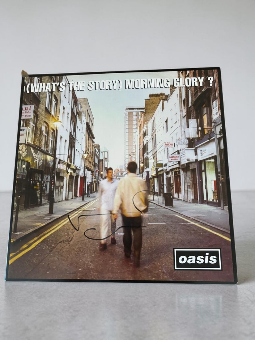 Noel Gallagher Oasis Signed Vinyl LP: This lot is a vinyl LP (What's The Story Morning Glory), autographed by Noel Gallagher of Oasis. If you wish to upgrade to a third party authentication with holographic QR code and item scoring, an ad