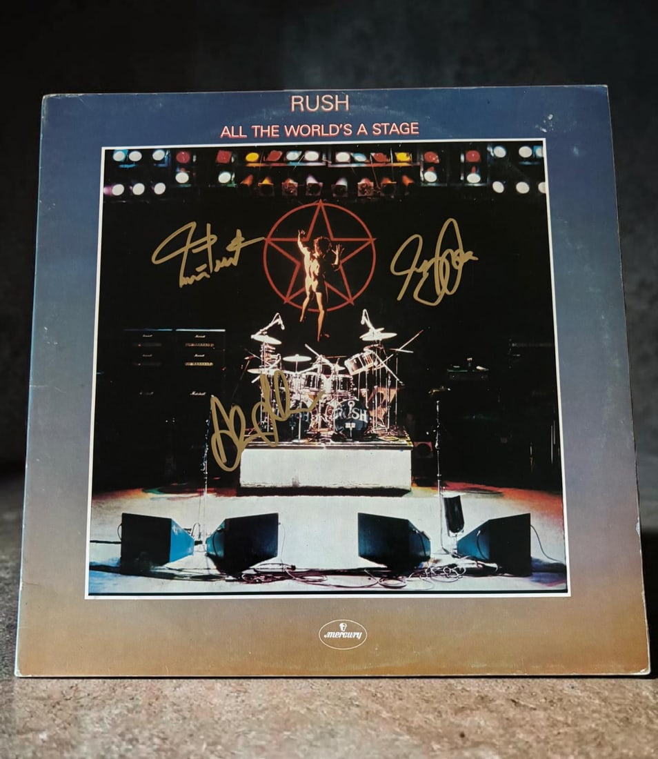 Rush Signed Vinyl LP: This lot is a vinyl LP (All The World's A Stage), autographed by Geddy Lee, Alex Lifeson and Neil Peart of Rush. If you wish to upgrade to a third party authentication with holographic QR code and ite