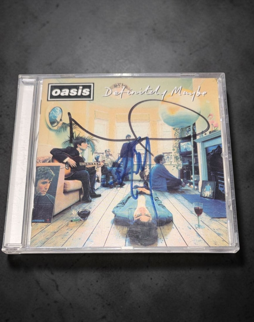 Oasis Signed CD: This lot is a CD (Definitely Maybe), autographed by Noel Gallagher and Liam Gallagher of Oasis. If you wish to upgrade to a third party authentication with holographic QR code and item scoring, an add