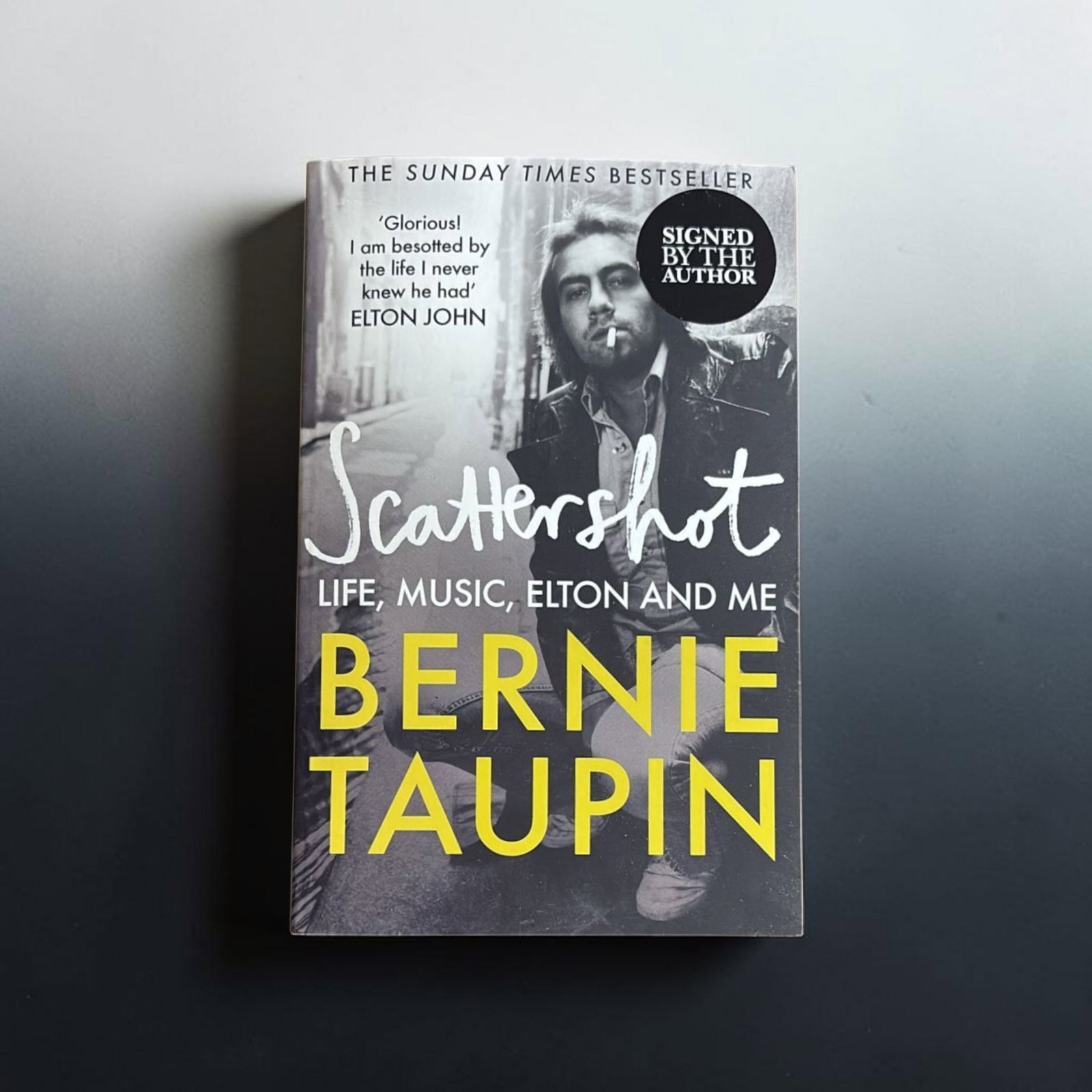 Bernie Taupin Signed Paper back Book: This lot is a paper back book (Scattershot), autographed by Bernie Taupin. If you wish to upgrade to a third party authentication with holographic QR code and item scoring, an additional charge of 30 