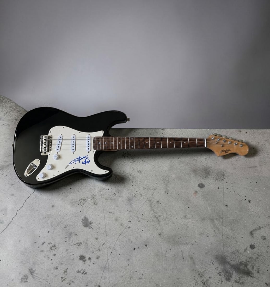 Angus Young AC/DC Signed Stratocaster Style Electric Guitar: This lot is a Stratocaster style electric guitar, autographed by Angus Young of AC/DC. If you wish to upgrade to a third party authentication with holographic QR code and item scoring, an additional c