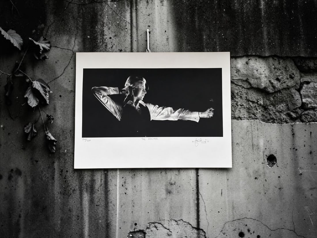 John Rowlands Signed The Archer David Bowie Lithograph: This lot is a 17x22" David Bowie lithograph (The Archer), autographed by John Rowlands. 243 out of 250. Slight crease in bottom left corner, but can be covered by framing. If you wish to upgrade to a 